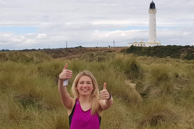 A runner holding a phone with thumbs up
